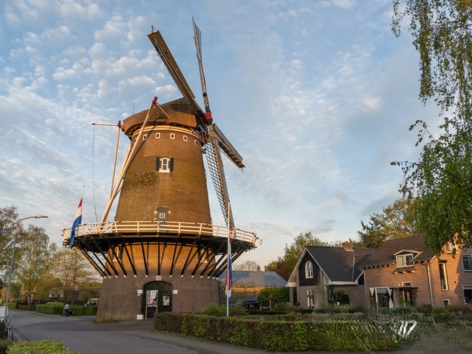 Zij aanzicht van de stenen stellingmolen Wilpermolen, Met blauwe lucht en zonsondergang 
