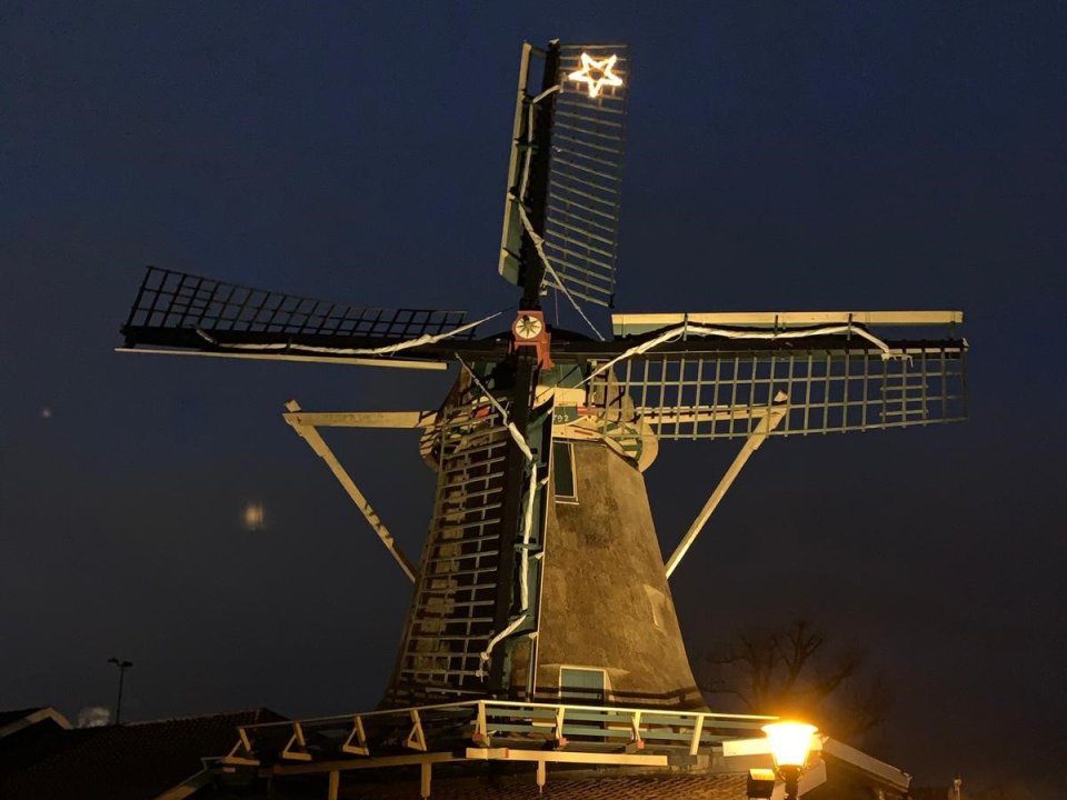 Avondfoto van de krijtmolen d'Admiraal in Amsterdam Buiksloot, met kerstster op de wieken. 