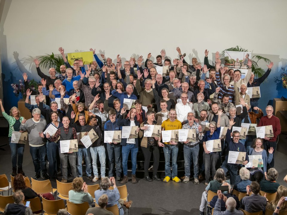 Grote groep van 100 mensen juichend die hun certificaat hebben ontvangen