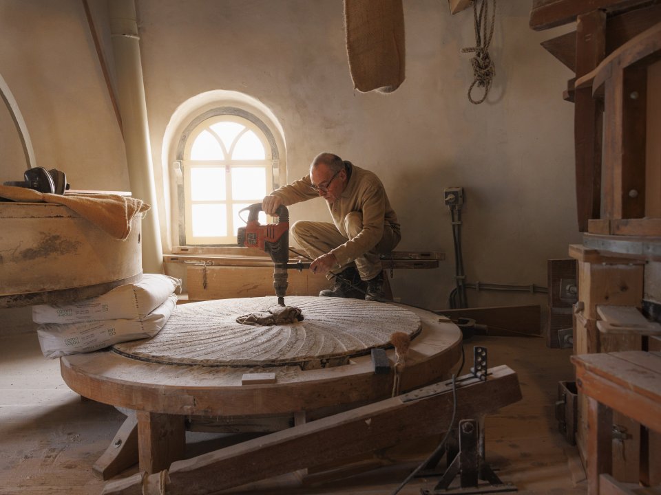 Molensteenmaker Hans Titulaer aan het werk